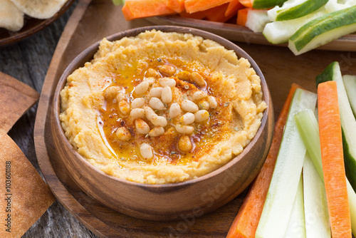 Traditional hummus in bowl with pita bread and vegetables