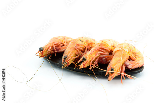 Boiled shrimp and  black plate on white background © yingtanthawarak