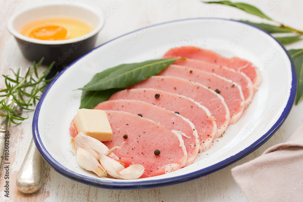 raw pork on dish with herbs,garlic and egg