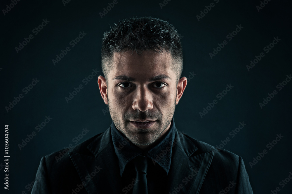 Fototapeta premium Fiery man close up portrait against dark background.