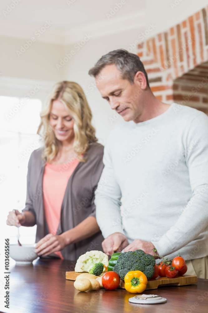 Cute couple slicing vegetables Cute couple slicing vegetables
