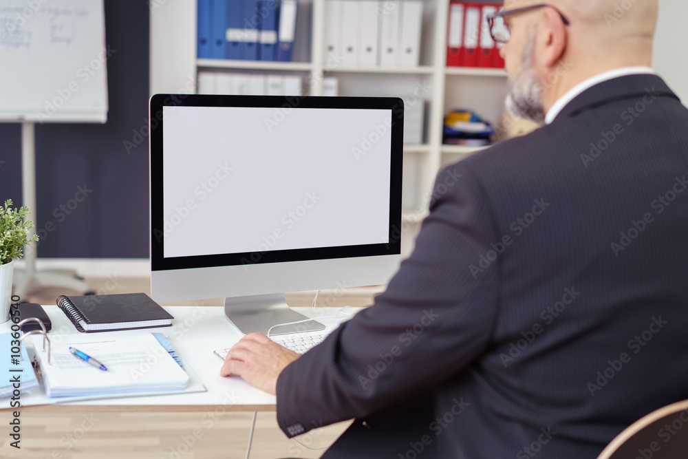 geschäftsmann am schreibtisch schaut auf seinen pc geschäftsmann am schreibtisch schaut auf seinen pc