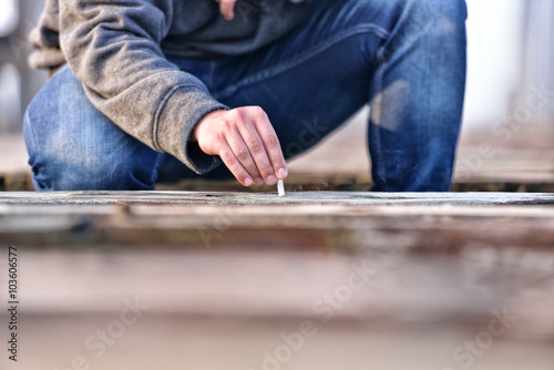 Hand of a young man extinguishing cigarette on a old bridge. Con
