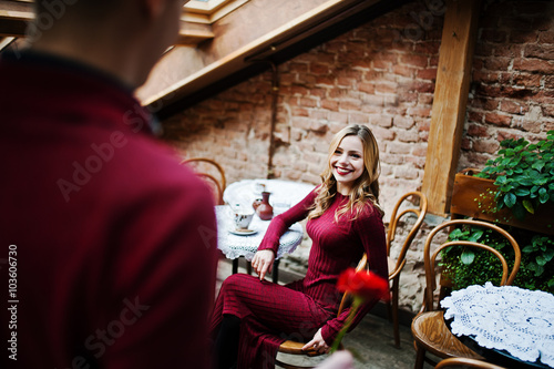 Young beautiful stylish couple in a red dress in love story at t
