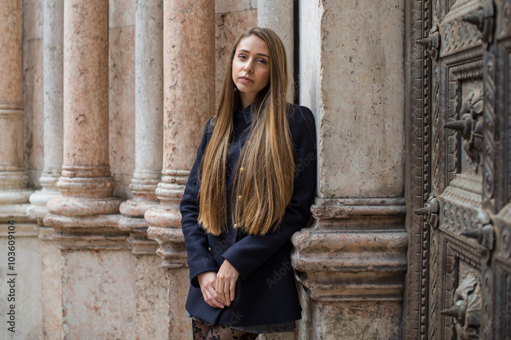 Intimate portrait of young blonde woman in the street. Parma, Italy.