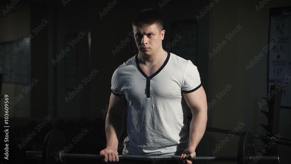 Closeup portrait of a muscular man workout with barbell at gym. Closeup portrait of a muscular man workout with barbell at gym.
