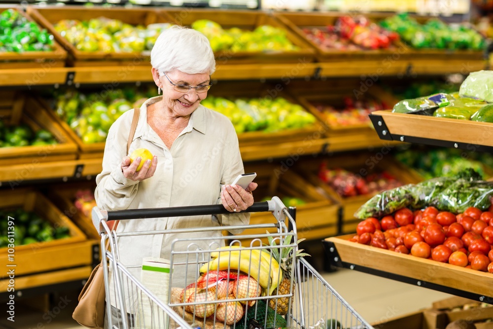Senior woman holding phone and an apple Senior woman holding phone and an apple