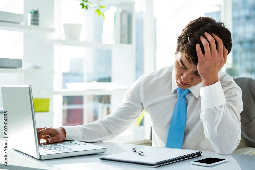 Tired asian businessman working at his desk