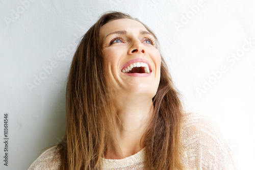 Obraz na plátne Beautiful middle aged woman laughing against white background
