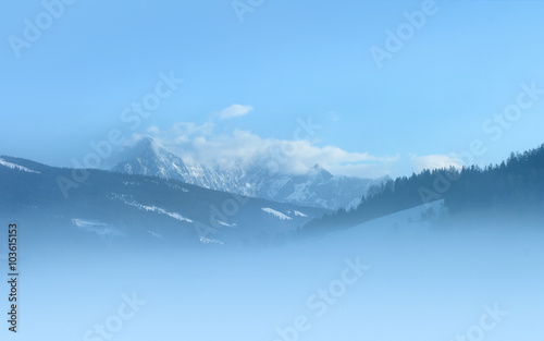 Snowy peaks at foggy morning. The glacier 'Dachstein' is located at the north Alps in Austria. Photo taken from 'Radstadt'.