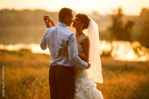 groom and bride are dancing on the background green forest and l