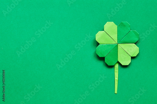 Green origami shamrock clover leaf paper background. St. Patrick's Day greeting postcard template. Space for copy, text, lettering.