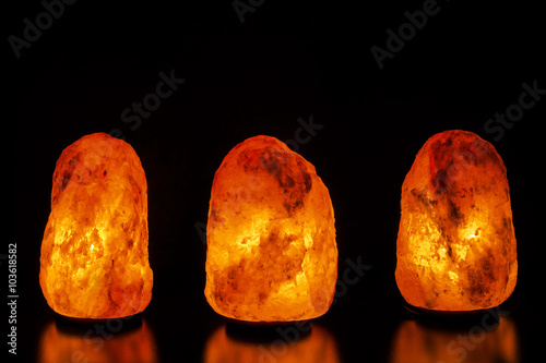 Three salt lamps on black background