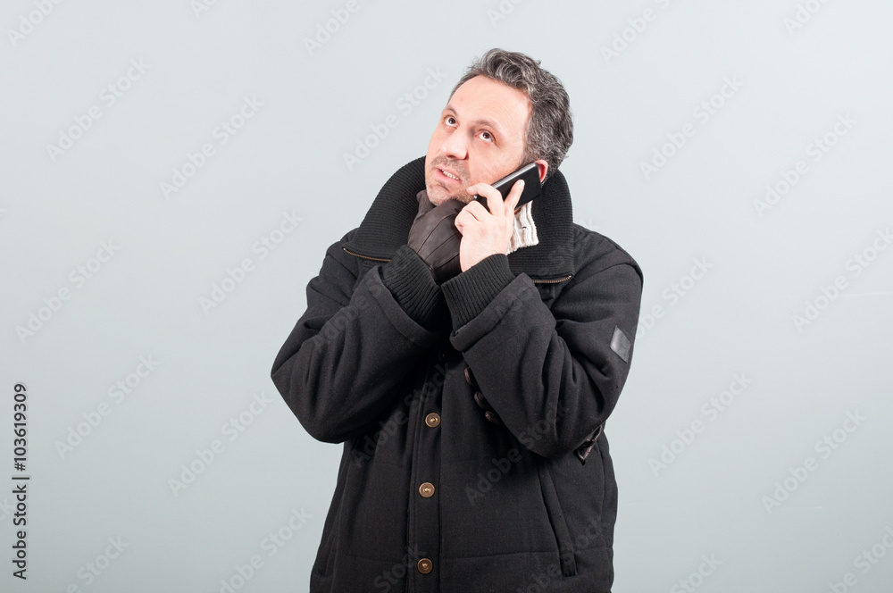 Young man thinking while talking on cellphone Young man thinking while talking on cellphone