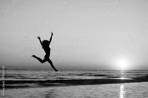 girl doing gymnastics on the beach at sunset