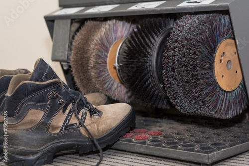 Wanderschuhe stehen bei Schuhputzgerät photo