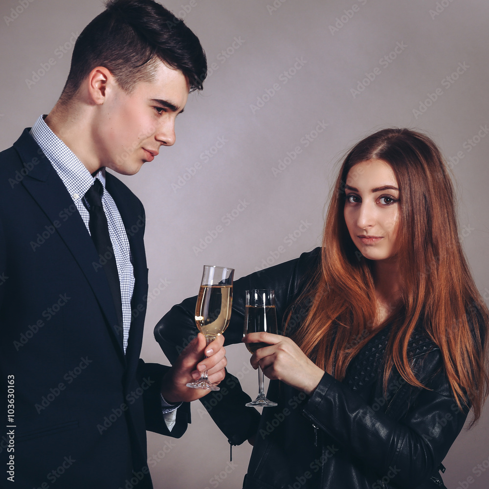 Portrait young couple with glass of champagne, wear evening dress and suit, glamour vogue style, sensual looking at camera, sitting indoors Portrait young couple with glass of champagne, wear evening dress and suit, glamour vogue style, sensual looking at camera, sitting indoors