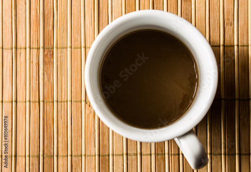 Coffee cup on a bamboo pad