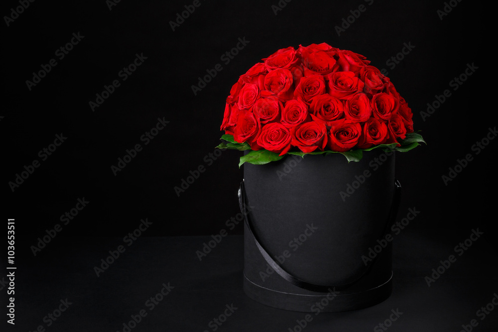Naklejka premium Romantic luxury red roses in a black gift box with space for logo on a black background studio,studio photography,spring is coming,international women's day