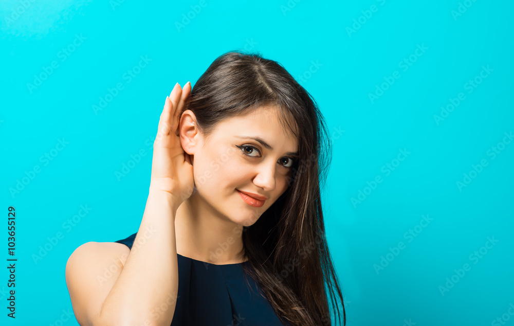 young woman on a blue background, eavesdropping