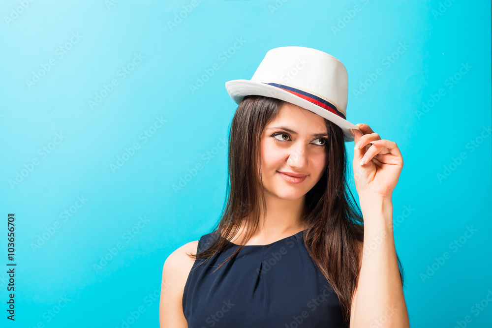 young woman in hat, blue background young woman in hat, blue background