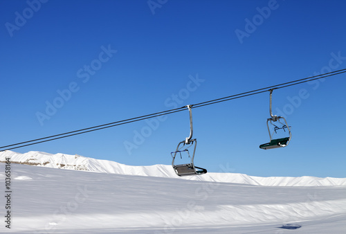 Chair-lift and blue clear sky at sun day photo