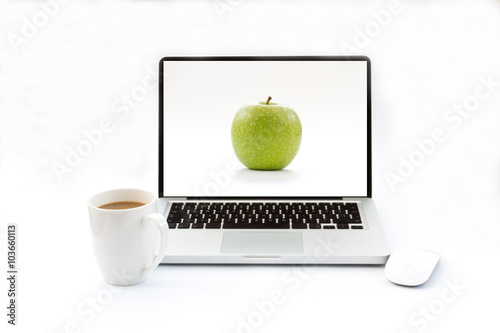 A laptop with an apple screen saver on an isolated white background. A white desk with a computer and hot drink to work at your desk.