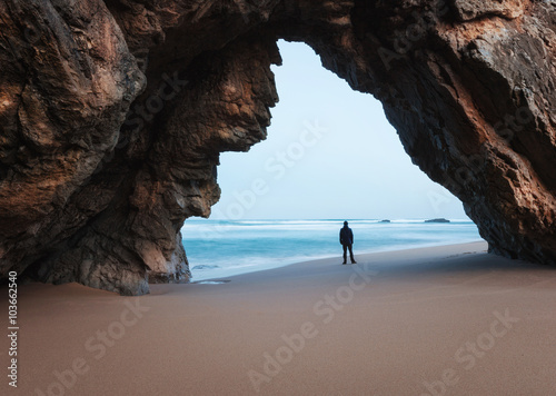Lonely man under the rocky arch