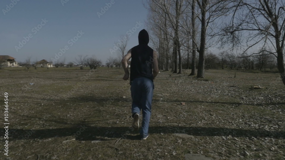 Young hooded man jogging in an abandoned place Young hooded man jogging in an abandoned place