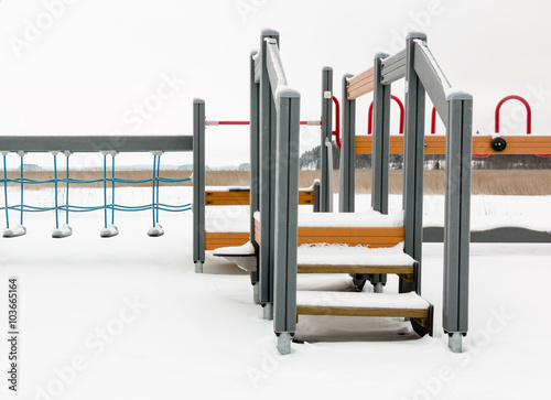 Climbing equipment at a playground in winter photo