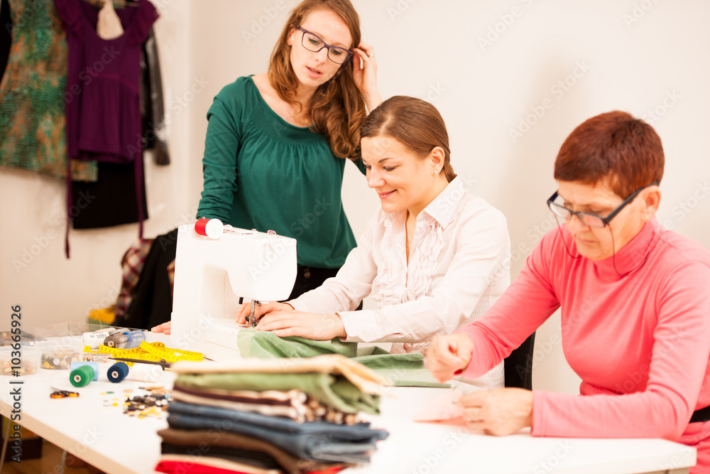 Fototapeta premium Three women are sewing on handcraft workshop. They are teaching