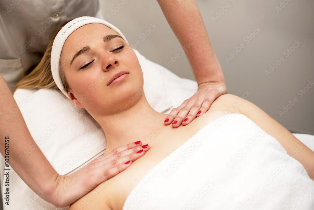 Young woman lying on massage table receiving face massage. Beaut Young woman lying on massage table receiving face massage. Beaut