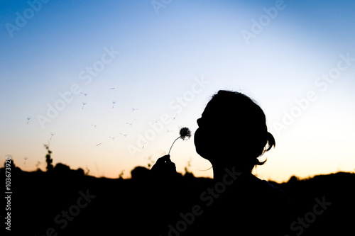 Woman blowing dandelion silhouette