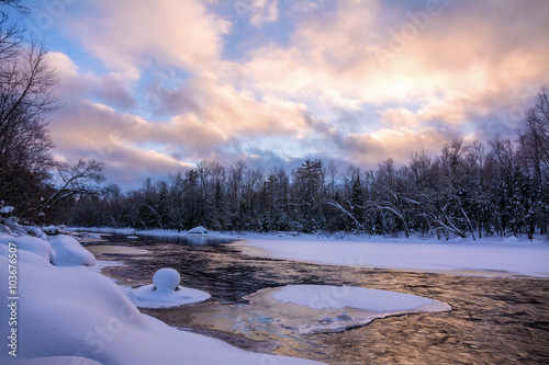 Patchy clouds drift low over a partially frozen Chippewa River near sunset; Northern Wisconsin photo
