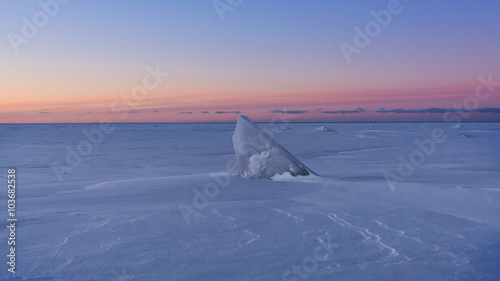 A stray piece of ice, reminiscient of a shark dorsal fin, juts up from the snow covering Lake Superior; Wisconsin.