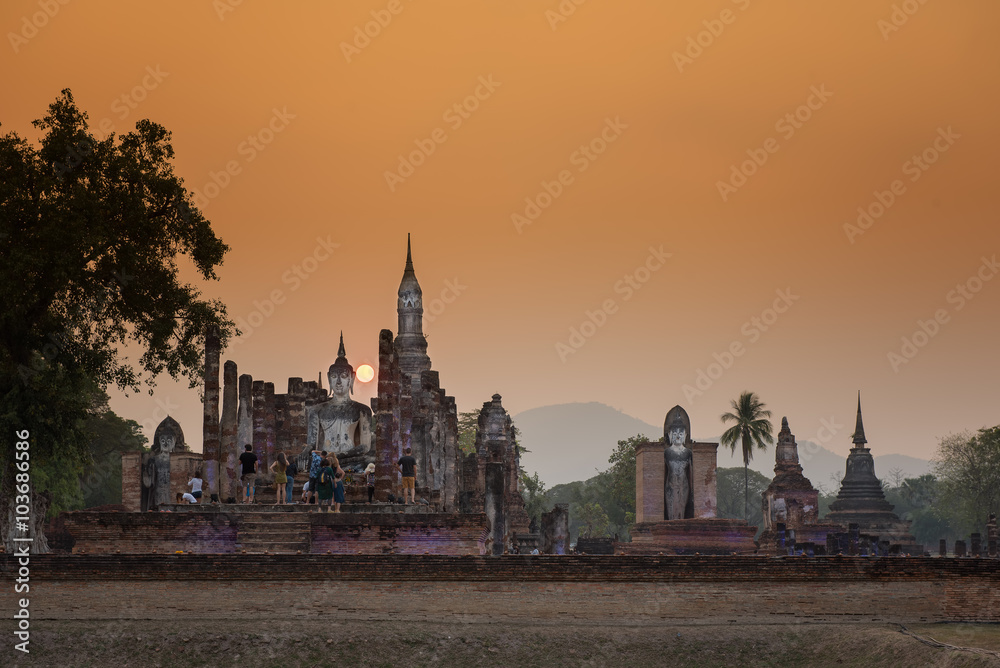 Ancient Buddha Statue at sunset Sukhothai historical park, Mahathat Temple ,Thailand.