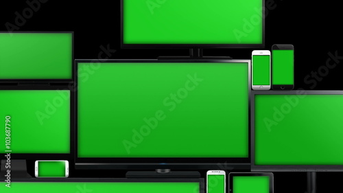 Many different types of screens. TVs, computer monitors, smartphones and tablets. They laid on each other in a pile isolated on a white background. They are all with a green screen. Zoom in & alpha