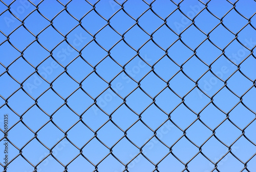 iron net fence against blue sky