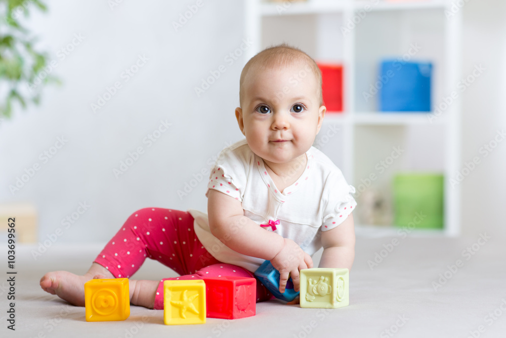 beautiful baby plays cubes on the floor and smiling beautiful baby plays cubes on the floor and smiling