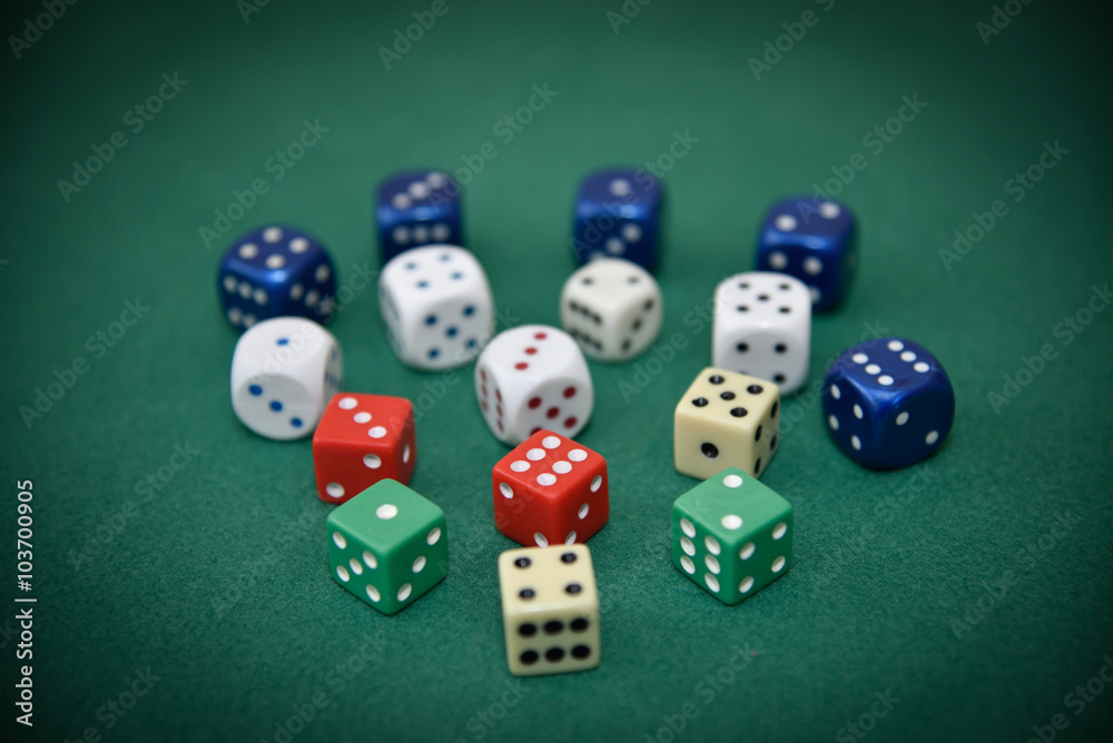 Different color dice on the green cloth. Selective focus. Different color dice on the green cloth. Selective focus.