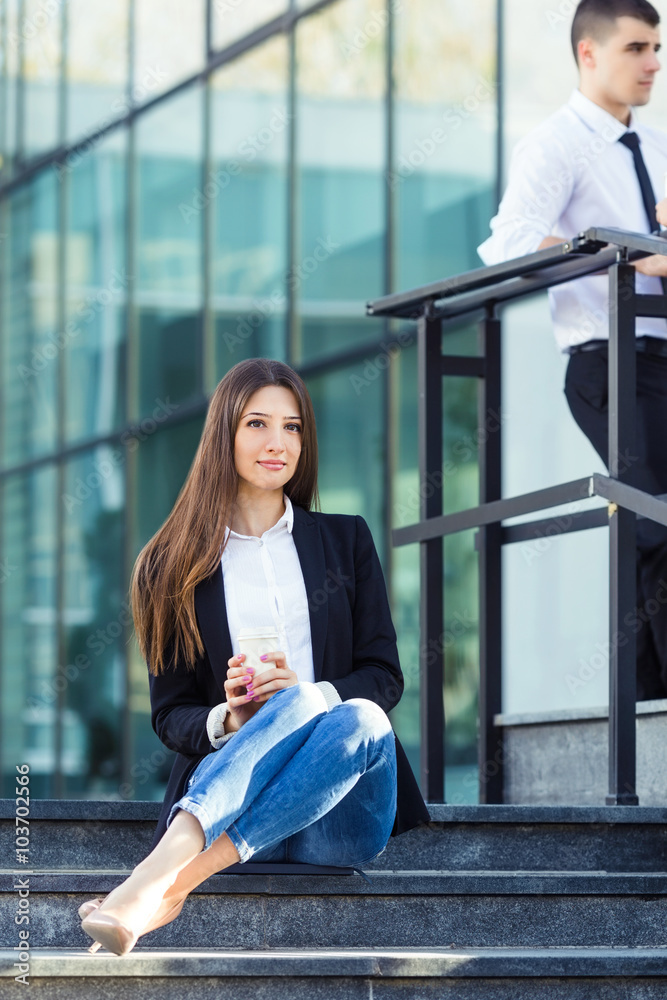 Young businesswoman on a break sitting on the stairs in front of the office