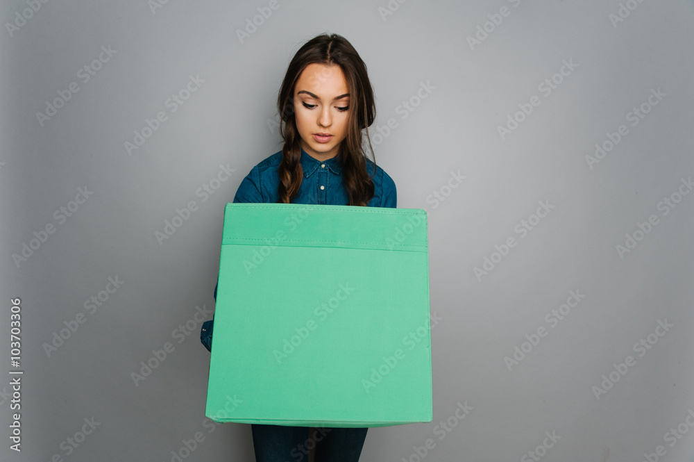 Obraz premium Attractive cute caucasian girl holding big square box in her hand ready to stock goods 