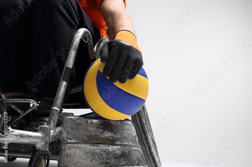 Niepełnosprawny na wózku inwalidzkim.Mężczyzna na sportowym wózku inwalidzkim z piłką 