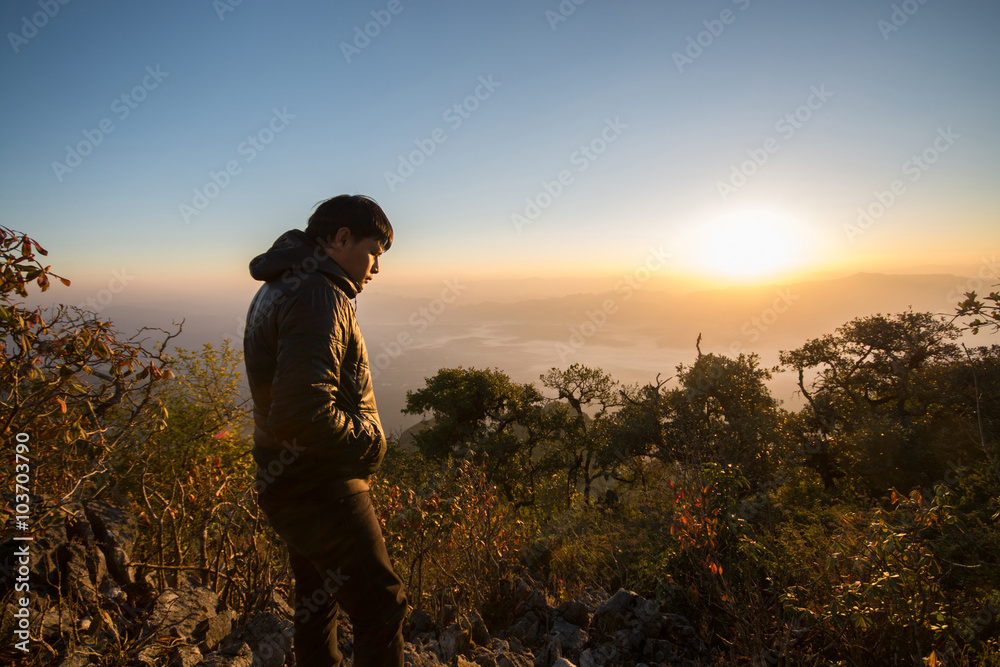 Fototapeta premium Young southeast asian man standing at mountain view in the morni