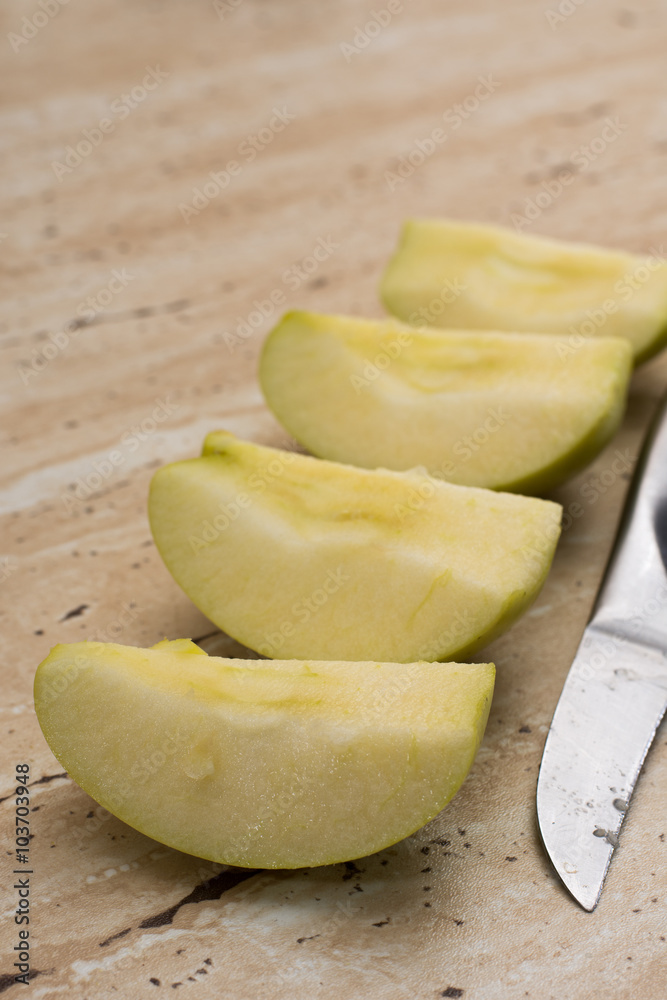 Slices of green sweet apple and metal knife Slices of green sweet apple and metal knife