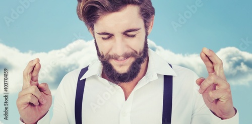 Composite image of hipster with fingers crossed photo