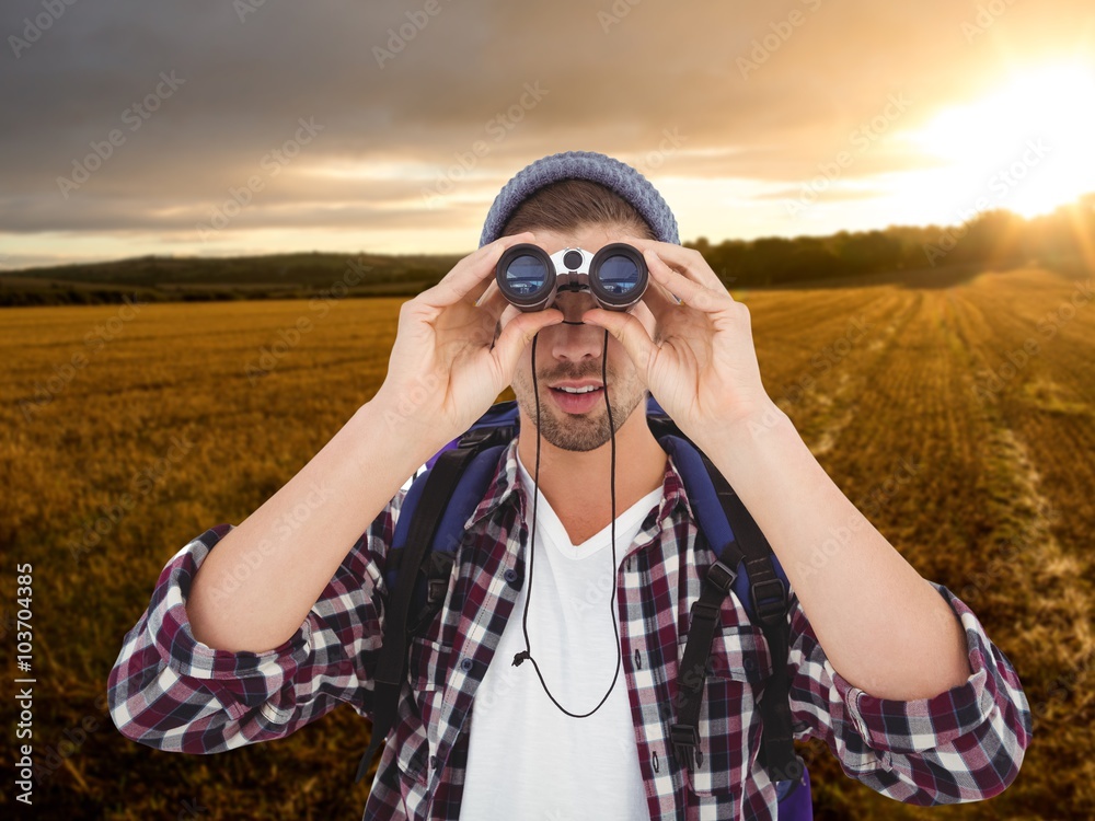 Composite image of hipster looking through binoculars Composite image of hipster looking through binoculars