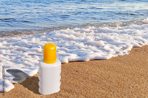 Sunscreen cream bottle on the beach