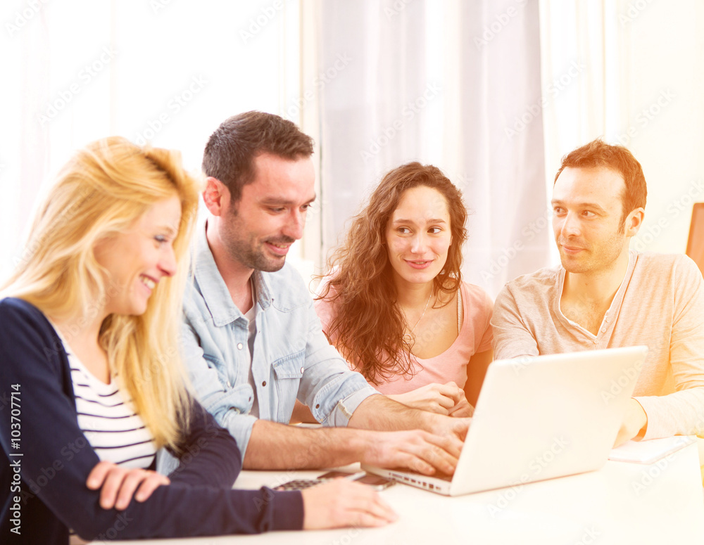 Group of 4 young attractive people working on a laptop Group of 4 young attractive people working on a laptop