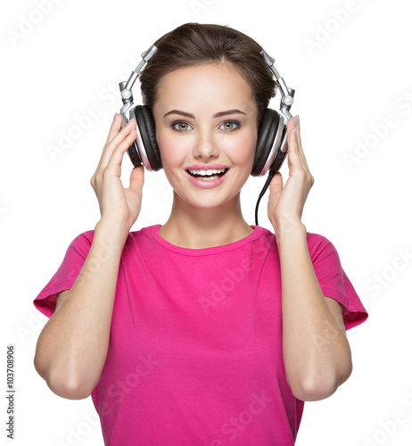 Cheerful young woman listening music with headphones